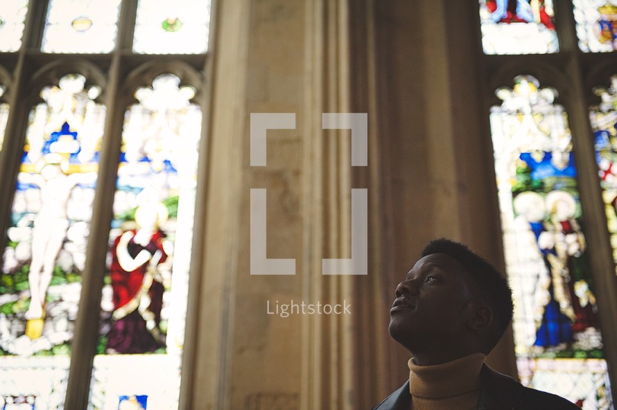 African American man looking up to God in a church 