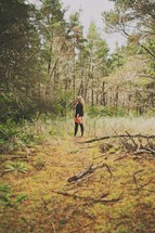 woman standing alone in the forest 