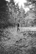 woman standing alone in the woods 