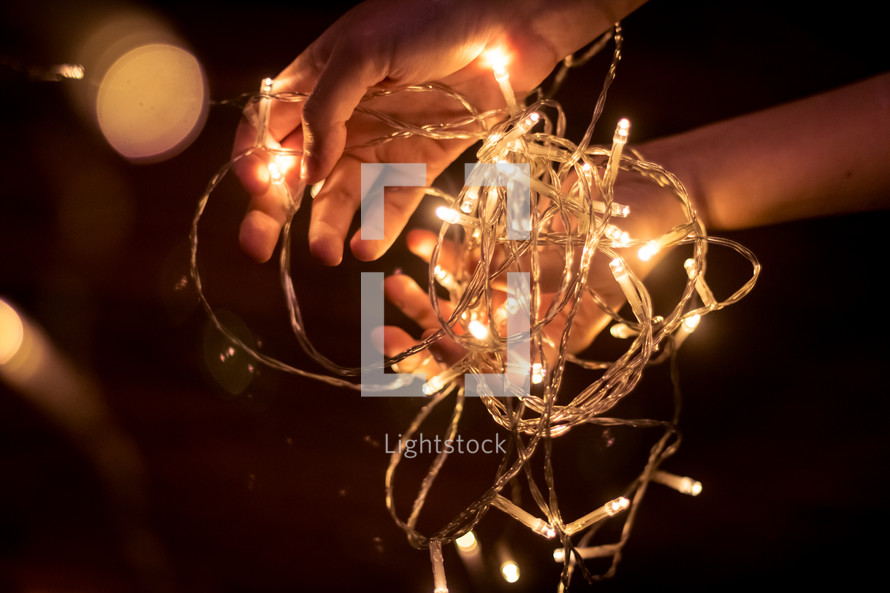 hands holding a string of lights 