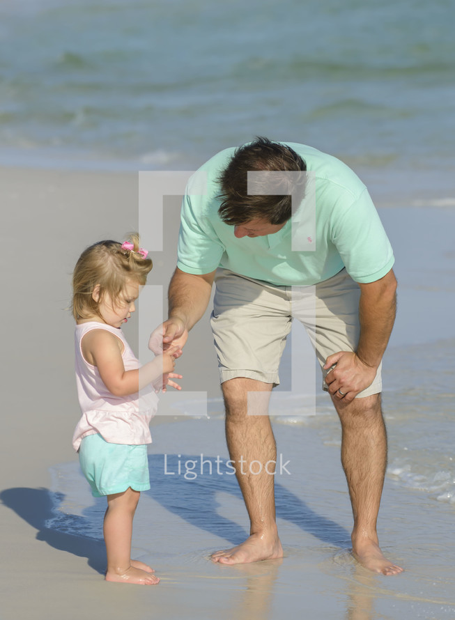a father with his daughter on the beach 