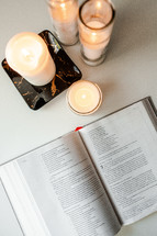 candles and pages of a Bible study book 