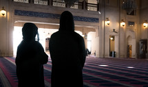 a man and woman standing in a mosque 