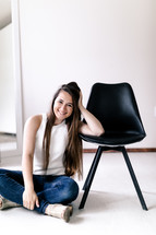 smiling young woman sitting on the floor 