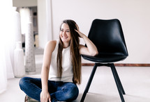 smiling woman sitting on a floor 
