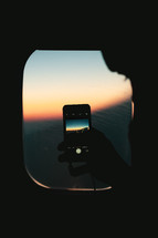 filming the sunset from a plane window 