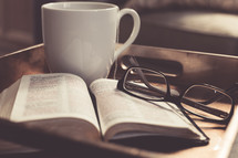Coffee cup, reading glasses, open Bible