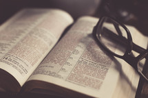 Reading glasses on the pages of a Bible 