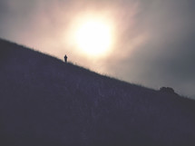 silhouette of a man standing on a hill in fog