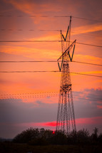 power lines at sunset under an orange sky 