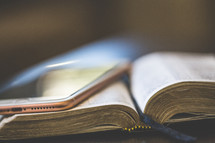 a cellphone on an open Bible 