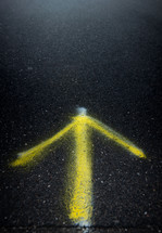 spray painted arrow on asphalt 
