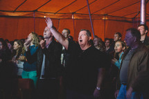 congregation standing with hands raised 