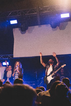 projection screen and worship leaders performing on stage 
