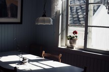 a kitchen table and a flower in a window 