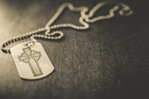 A dog tag with a cross on it. 