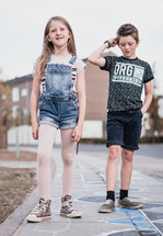 kids standing on a neighborhood sidewalk 