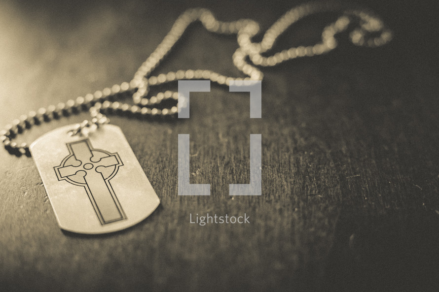 A dog tag with a cross on it. 