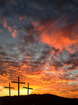 silhouette of three cross and a fiery sunset 