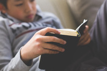 A boy reading a Bible