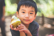 a boy child eating a pear 