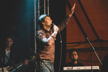man on stage holding a microphone 