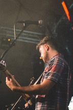 man on stage playing a guitar 