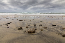rocks on wet sand on a beach 