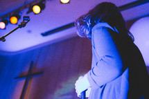 a woman holding a microphone during a worship service 