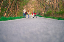 a family going on a walk outdoors down a rural road 