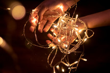 hands holding a string of lights 