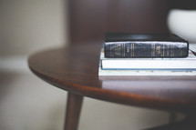 Bible and books on an end table 