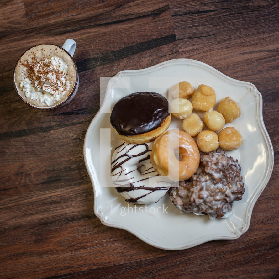 Plate of donuts with coffee with whipped cream and cinnamon