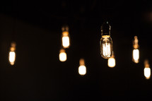hanging glowing lightbulbs against darkness 