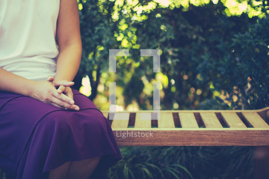 woman sitting on a bench in prayer 