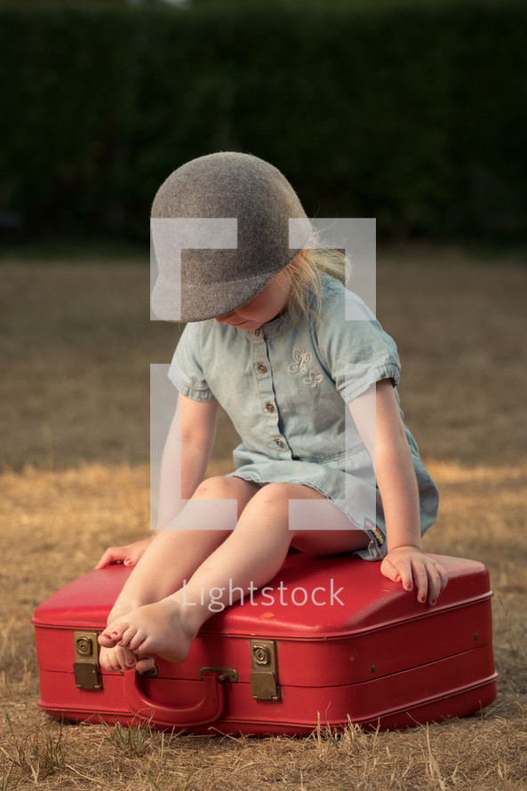 a toddler sitting on a suitcase 