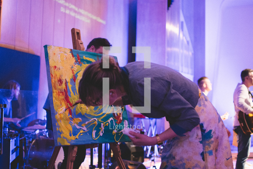 a woman painting during a worship service 