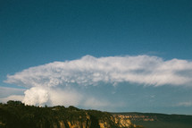 A huge cloud formation over a canyon.