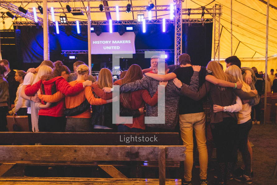 group of people hugging at a concert 