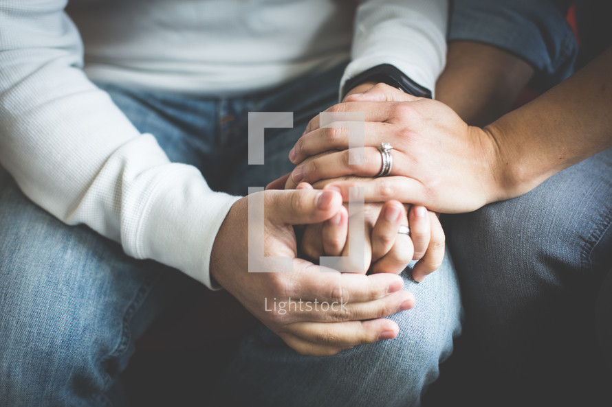 a couple holding hands in prayer