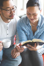 A man and woman reading a Bible 