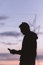 silhouette of a man holding a cellphone 