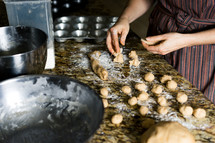 a woman rolling dough in a kitchen 