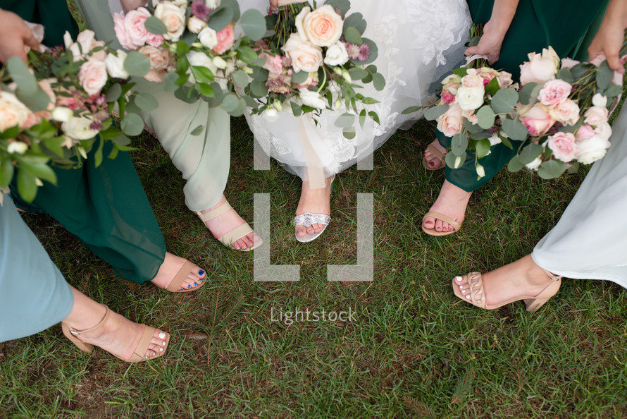 Bride and bridesmaids feet with bouquets
