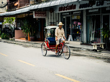 man driving a pedicab bicycle 