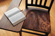 a student desk with a Bible 