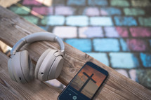 Headphones and Bible app on a bench 