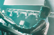 a man playing a keyboard on stage 