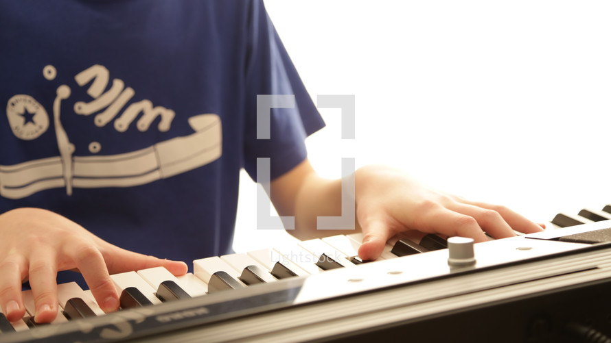 a boy playing a keyboard 