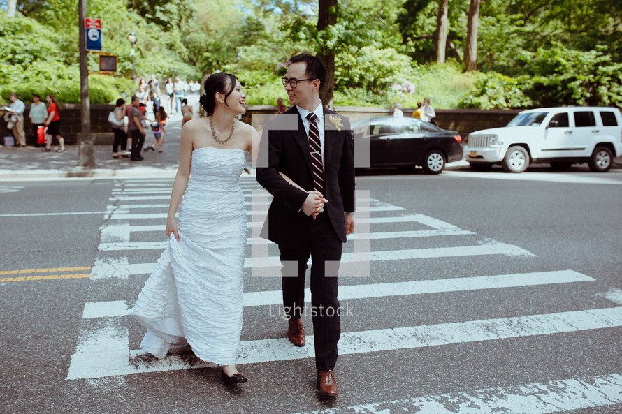 bride and groom crossing at a crosswalk 